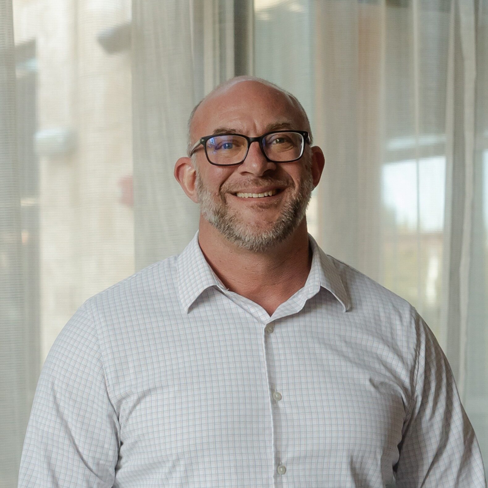 dr-christoipher-sq Male orthodontist wearing glasses smiling in office at Walla Walla Orthodontics