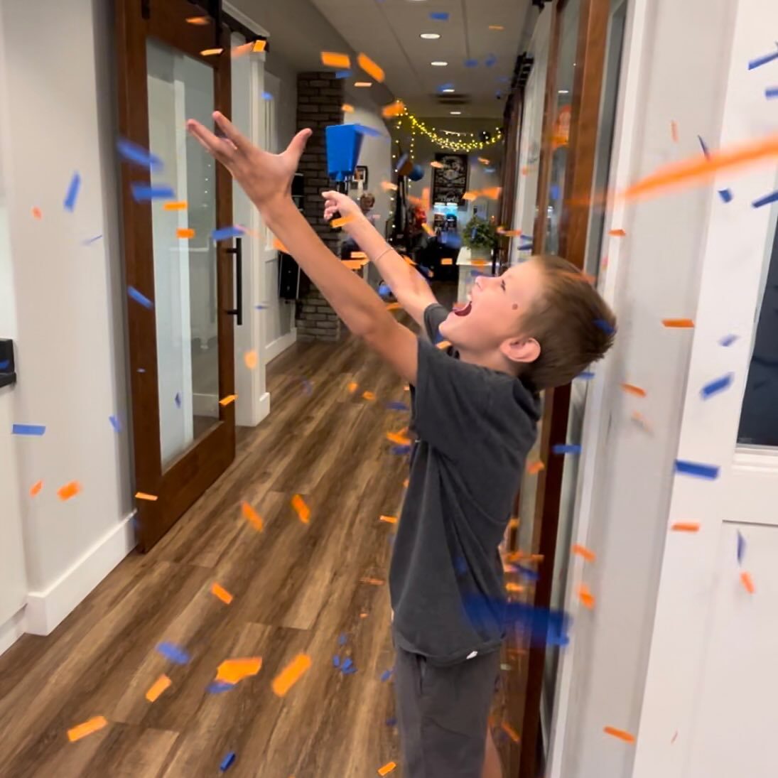 Child celebrating with confetti in the orthodontic office