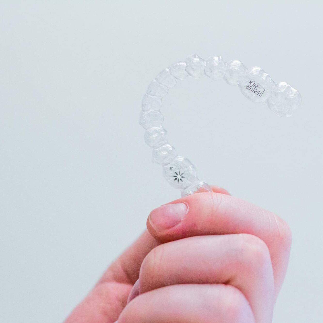 Hand holding a custom clear aligner